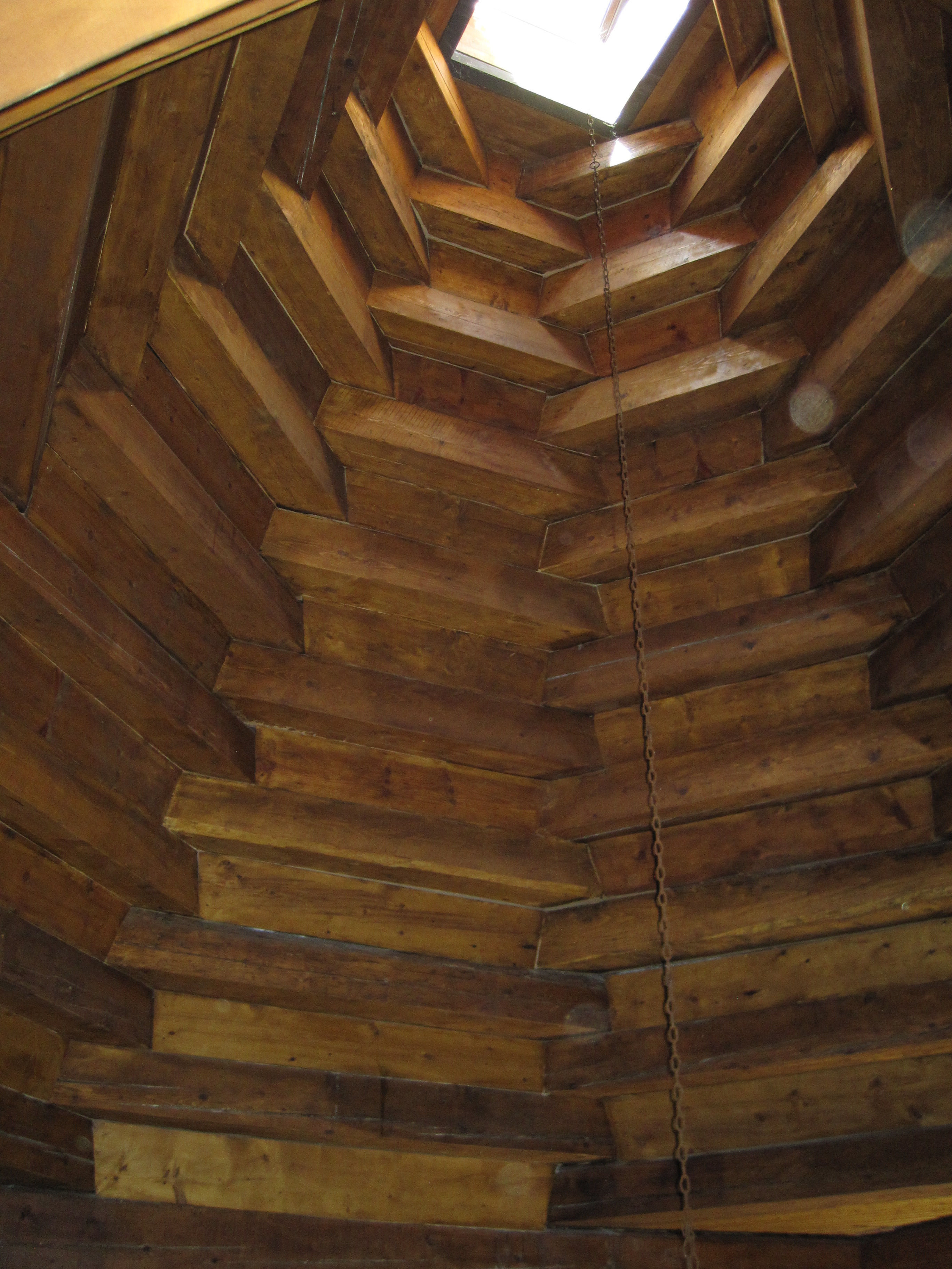 Interior, conical wooden darbazi roof with smoke hole and hearth chain.