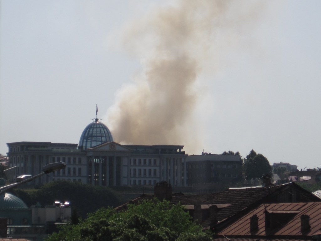 Presidential Palace, Tbilisi, with a cloud of smoke rising from behind it.